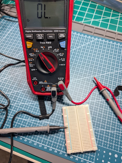 Using a multimeter in continuity mode to test which breadboard holes are connected.